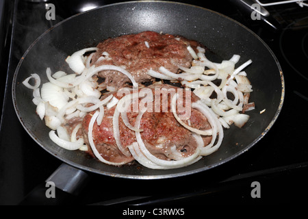 Materie hamburger polpette con cipolle in rivestito in Teflon padella. Foto Stock