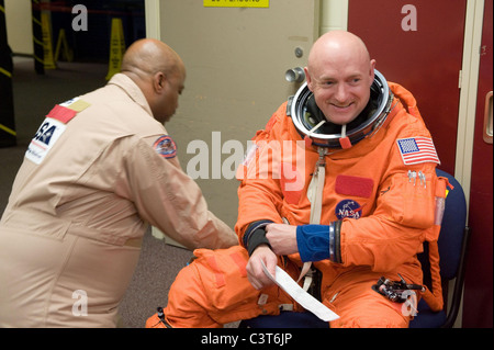 La preparazione per il volo Commander Mark Kelly è assistita da United Space Alliance suit tecnico Andre Denard prima di un post inserimento/de-orbita sessione di formazione in una fusoliera completa Trainer mock-up in Johnson Space Center del veicolo spaziale mock-up Facility. Credito di immagine: la NASA Aprile 12, 2010 Foto Stock