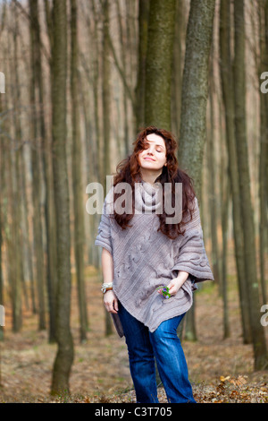 Giovane donna facendo una passeggiata in un bosco di faggio Foto Stock