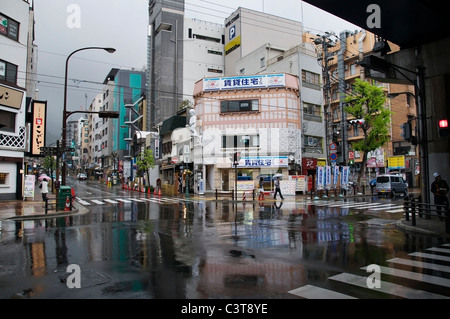 Intersezione nel centro di Kobe su un umido aprile giorno mostra il quartiere dello shopping di Sannomiya. Foto Stock