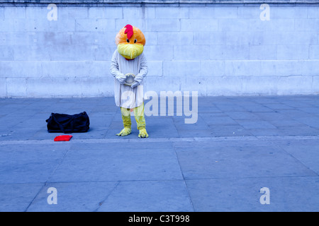 Un attore in un uccello vestito fa un triste pongono contro uno sfondo semplice Foto Stock