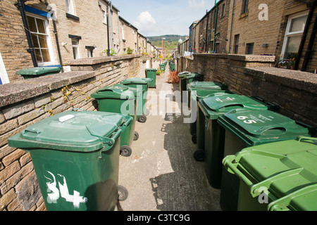 Cestini della spazzatura su un vicolo tra case a schiera in Saltaire, nello Yorkshire, Regno Unito. Foto Stock