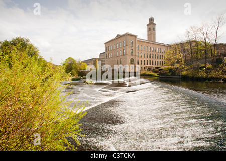 Salts Mill in Saltaire, nello Yorkshire, Regno Unito e uno stramazzo sul fiume Aire. Il mulino è stato aperto nel 1853 da Tito, sale per elaborare gli alpaca Foto Stock