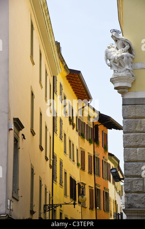 Strada stretta a Udine centro città con un affresco di pietra e CCTV su una parete, Udine, Italia Foto Stock