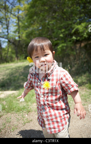 Baby Boy con tarassaco fiori nei capelli Foto Stock