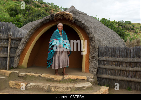 Sotho donna di fronte a capanna, Basotho Villaggio Culturale, Golden Gate Highlands National Park, Sud Africa Foto Stock