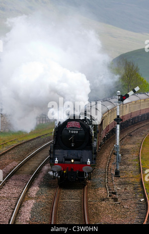 Anni '50 50 BR Classe 8 Pacifico No 7100 naso del Duca di Gloucester  Cumbrian Mountain treno espresso a vapore presso la stazione ferroviaria Kirby Stephen, Cumbria, Regno Unito Foto Stock