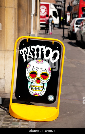 Un segno per i tatuaggi al di fuori di un salone per tatuaggi, Cambridge Regno Unito Foto Stock