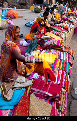 Donne e uomini indiani che vendono vestiti, sari, tessuti, tessuti al mercato cittadino a Jodhpur, Rajasthan, India, Asia Foto Stock