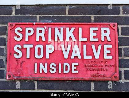 Arresto di sprinkler segno della valvola sul lato di un edificio in Brighton Foto Stock