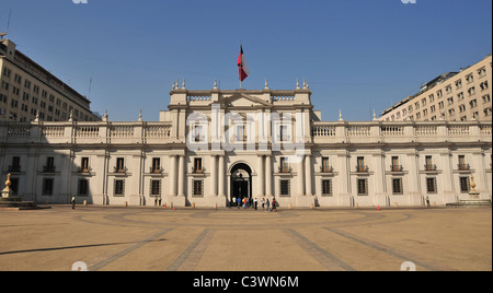 Cielo blu vista il Palazzo Presidenziale di La Moneda, Bandiera cilena e turisti in Piazza della Costituzione, Santiago del Cile Foto Stock