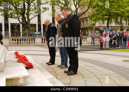 Tre uomini laici ghirlande di papavero a una cerimonia wreathlaying Foto Stock