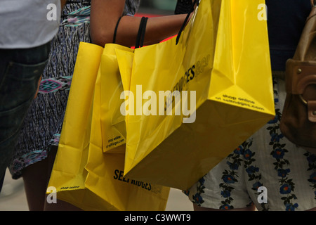 Una femmina portando vari sacchetti di Selfridges a Londra Foto Stock