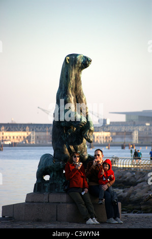 Una famiglia giovane di fronte ad una statua di bronzo di orso polare con i cuccioli da Holger Wederkinch, 1929, Langenlinie, Copenhagen, Danimarca Foto Stock