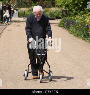 Anziani Senior Citizen a piedi con un telaio nel parco. Foto Stock
