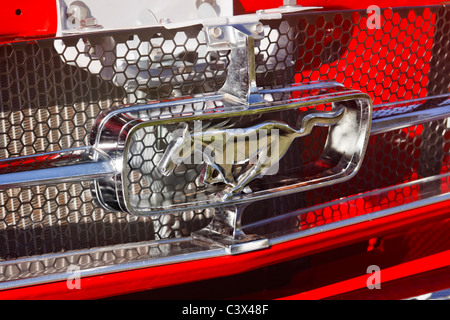 Grill ed emblema di un classico rosso 1965 Ford Mustang. Foto Stock