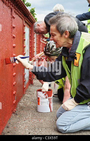 Sustrans volontario rangers il lavoro sulla costa a costa c2c traccia del ciclo di verniciatura di un ponte a Stanley, Co. Durham, England, Regno Unito Foto Stock