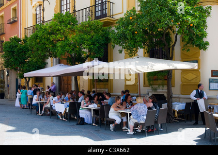Scena di strada, Siviglia, Spagna. Per coloro che godono di bere e mangiare presso un outdoor cafe bar con ombrelloni. Foto Stock