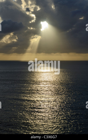 Il sole esplode attraverso la nuvola al tramonto sul canale di Bristol vicino a Ilfracombe, Devon, Inghilterra. Foto Stock