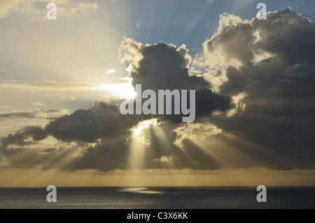 Il sole esplode attraverso la nuvola al tramonto sul canale di Bristol vicino a Ilfracombe, Devon, Inghilterra. Foto Stock