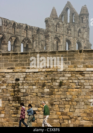 I turisti di grado 1 elencati monastero benedettino rovine Whitby Abbey durante un mare fret (mare di nebbia) North Yorkshire Inghilterra Europa Foto Stock