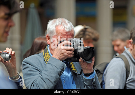 Il celebre fotografo Roger Bamber al lavoro per le strade di Brighton durante il festival artistico di quest'anno (ora deceduto) Foto Stock