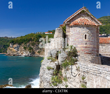 Storica torre di avvistamento costruita di pietra grezza su un vecchio muro della città che si affaccia sul mare in Montenegro Foto Stock