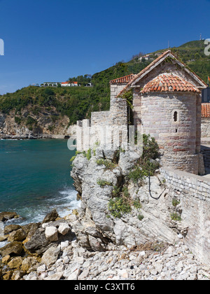 Storica torre di avvistamento costruita di pietra grezza su un vecchio muro della città che si affaccia sul mare in Montenegro Foto Stock