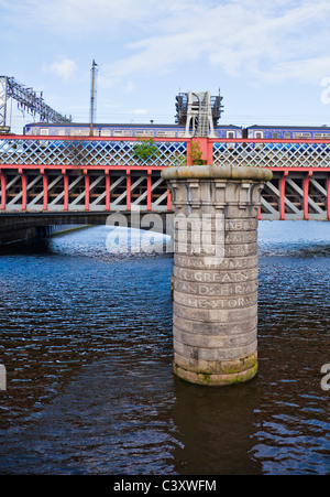 Il treno attraversa la seconda Caledonian Ponte Ferroviario sul fiume Clyde nel centro di Glasgow. Il molo di granito del primo ponte ferroviario. Foto Stock