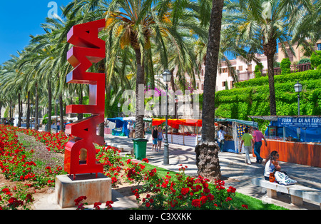 Mercato di PALMA MALLORCA ALL'APERTO Red Palma verticale segno di scultura su Av.de Gabriel Roca con palm alberata mercato locale bancarelle Palma Mallorca Spagna Spain Foto Stock