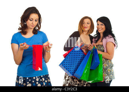 Triste donna di piccola shopping bag e due donne egoista con molte borse ridendo e scherzando sulle loro amico isolato su bianco Foto Stock