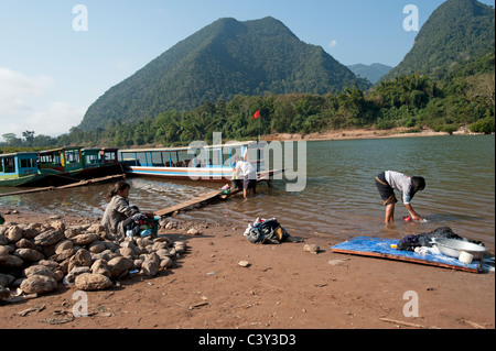 Servizio lavanderia Lavaggio nel fiume al Muang Ngoi a nord di Luang Prabang nella Repubblica democratica popolare del Laos Foto Stock