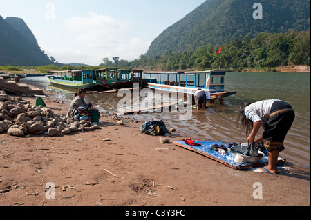 Servizio lavanderia Lavaggio nel fiume al Muang Ngoi a nord di Luang Prabang nella Repubblica democratica popolare del Laos Foto Stock