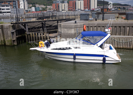 A Swansea, West Glamorgan, Galles, un power boat entra nella marina dopo aver attraversato il fiume Tawe barrage Foto Stock