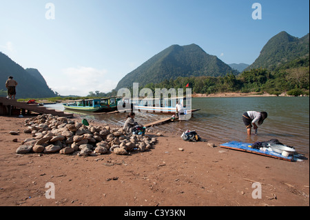 Servizio lavanderia Lavaggio nel fiume al Muang Ngoi a nord di Luang Prabang nella Repubblica democratica popolare del Laos Foto Stock