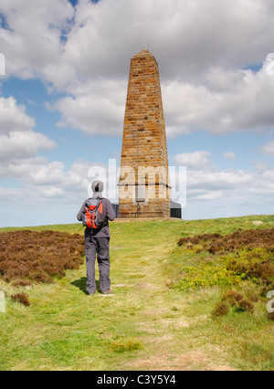 Escursionista maschio vicino a Captain Cook monumento su Easby moor vicino grande Ayton, North Yorkshire, Inghilterra Foto Stock