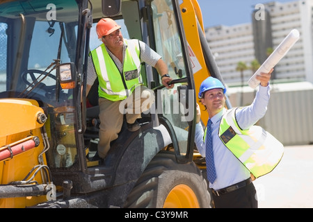 Architetto parlando di operaio edile Foto Stock