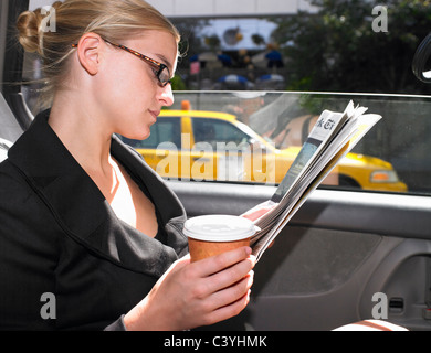 Business donna lettura carta news in cabina Foto Stock