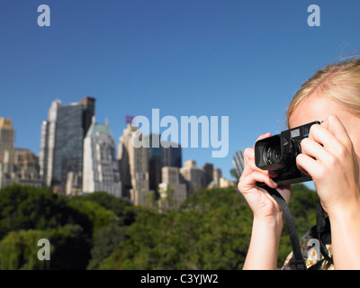 La donna a scattare foto in central park Foto Stock