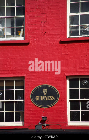 Guinness segno rosso su edificio in mattoni in Brighton nel Maggio Foto Stock