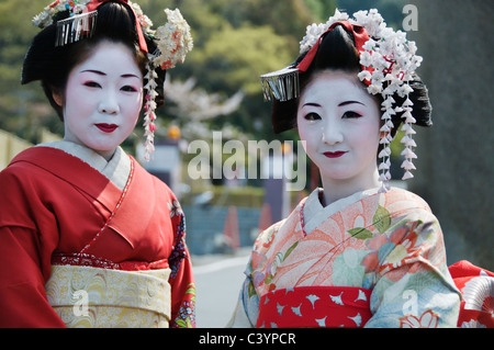 Due belle geisha pongono all'aperto su una giornata di primavera a Kyoto, in Giappone. Foto Stock