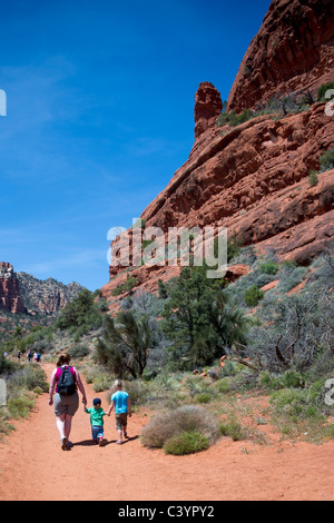 Madre e 2 bambini piccoli tenendo le mani, escursionismo da Bell Rock, Sedona, in Arizona, Stati Uniti d'America Foto Stock