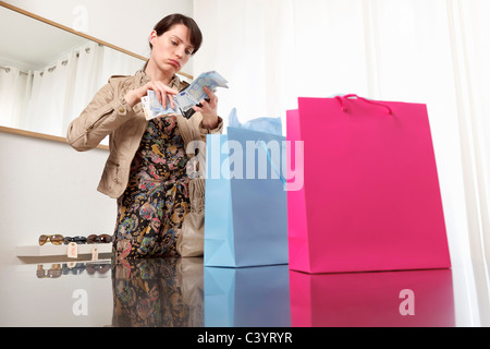 Donna controllando il denaro da borsa Foto Stock