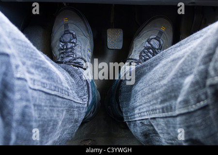 Un mans i piedi sui pedali di un'auto. Foto Stock