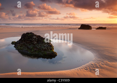Rockpools su una sabbia deserte bech al tramonto, Bedruthan Steps, Cornwall, Inghilterra. Molla (maggio) 2011. Foto Stock