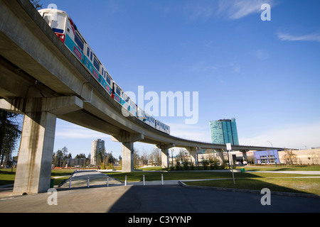 Lo Skytrain passa overhead, Holland Park, Surrey centrale, BC, Canada. Foto Stock