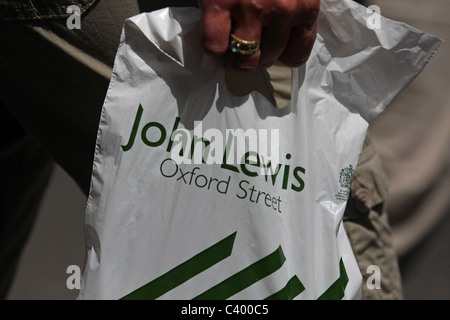 Una plastica John Lewis shopping bag trasportato Foto Stock