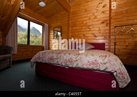 Bella camera da letto caldo interno del mountain lodge. Fox Glacier Lodge, Fox Glacier, Costa Ovest, South Island, in Nuova Zelanda. Foto Stock