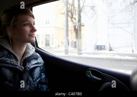 Donna che guarda fuori della finestra auto Foto Stock