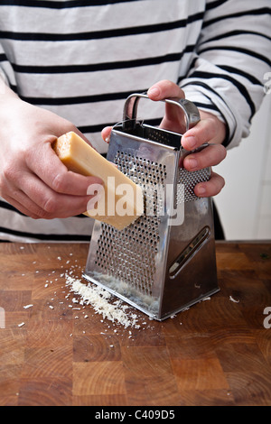 Lo chef femmina reticolo di parmigiano, preparare il cibo italiano. Foto Stock